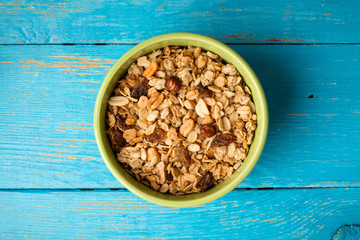 Granola in bowl on blue rustic wooden background