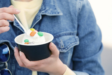 Fototapeta na wymiar Young girl eating tasty yogurt ice cream, closeup