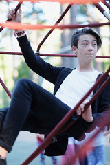 Teenager in the park on a rope attraction