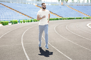 Sporty young man running at stadium