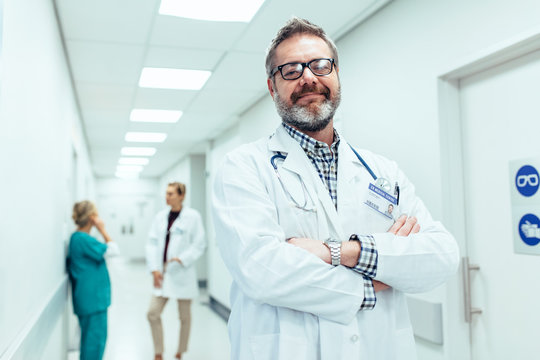 positive doctor standing in hospital hallway