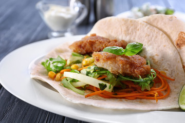 Delicious fish taco on white plate on blue dark table