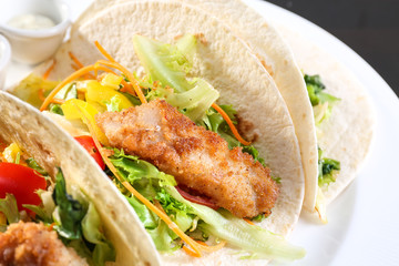 Delicious fish tacos on white plate, close up