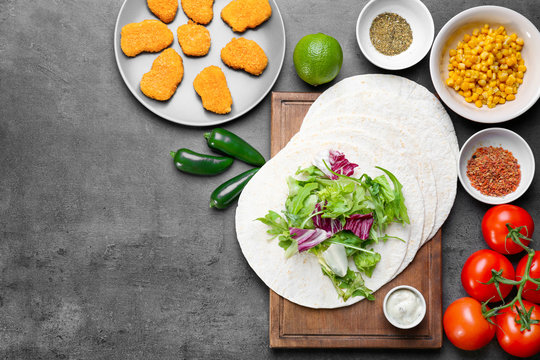 Ingredients for fish tacos on dark grey background