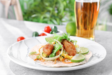 Delicious fish taco on plate on grey table