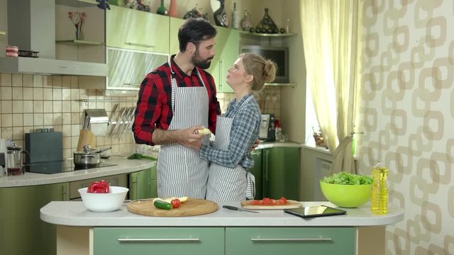 Woman and man eating apple. Young people in the kitchen. Dieting with your partner.