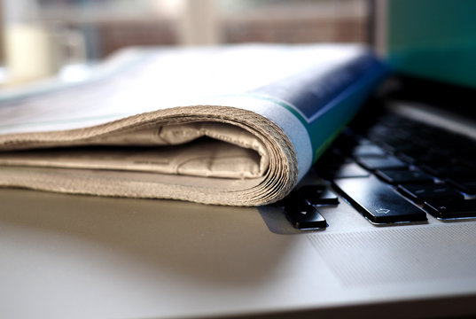 Newspaper on keyboard of laptop