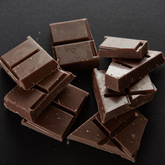 Broken chocolate bar on a black background