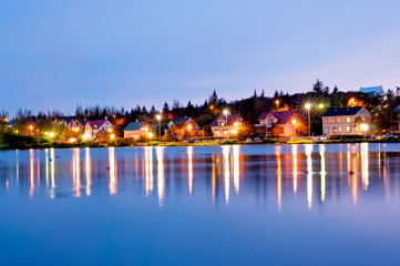 Night view downtown Reyjkjavik over the Tjornin lake in Iceland.