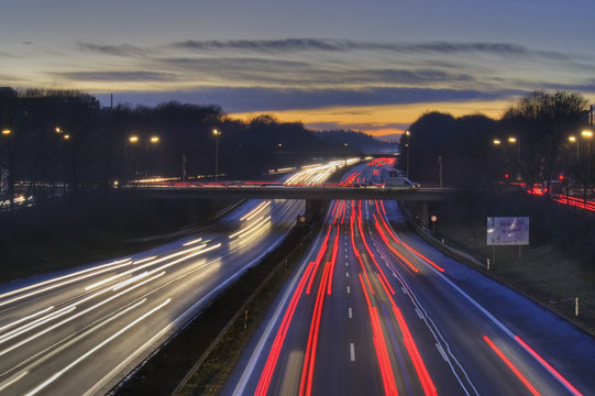 Autobahn A96, D&auml;mmerung und Nacht mit farbigen Spuren fahrender Autos. M&uuml;nchen, Bayern, Deutschland