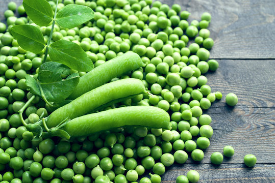 Green peas on a wooden surface, top view. 