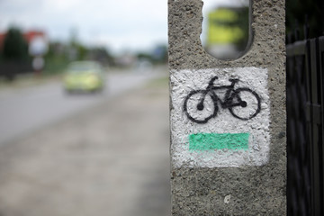 oznakowanie drogi - czarny rower i zielona linia na białym tle