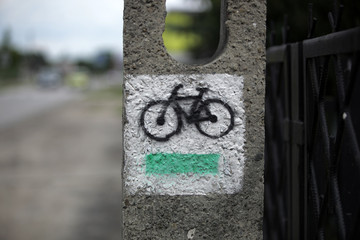oznakowanie drogi - czarny rower i zielona linia na białym tle