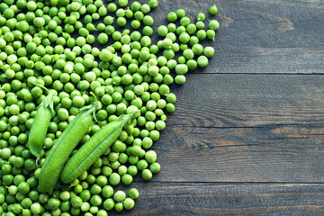 Green peas on a wooden surface, top view. 