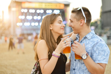 Couple drinking beer and having fun at music festival 