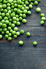 Green peas on a wooden surface, top view. Textural background