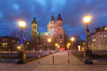 Saint Lucas Church, the largest Protestant church in Munich, and bridge across Isar River at night, Bavaria, Germany