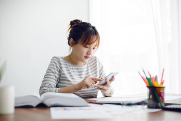 Young Asia woman working with smart phone at home