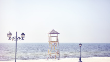 Retro old film stylized picture of a lifeguard tower on an empty beach.