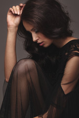 Young slim girl in black sexy fashionable dress.