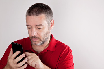 Mature man searching for information in his cell phone