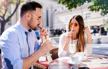 Romantic couple drinking coffee and lemonade, having a date in the cafe. Dating, love, relationships