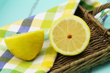 Two juicy lemon halves on wicker tray, closeup
