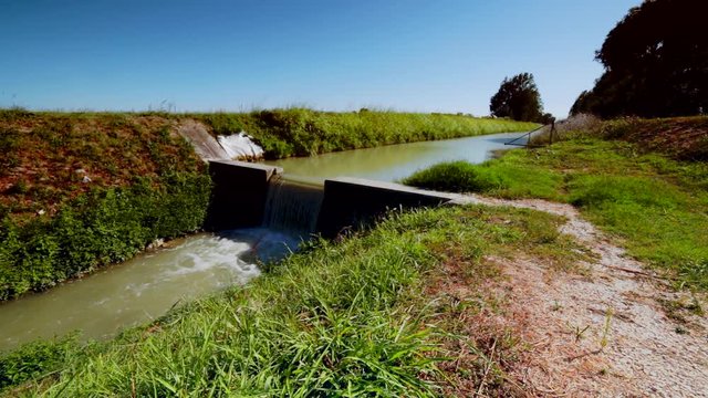 water flowing in agricultural channel for irrigation in Italy, color graded clip