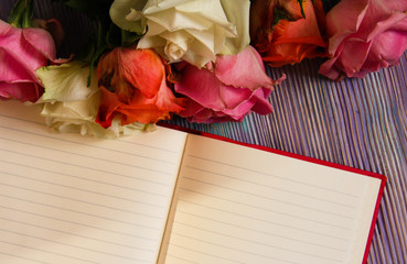 Colorful roses and an open notebook