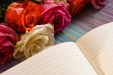 Colorful roses and an open notebook