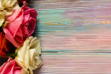 Colorful wooden background with red, pink and white roses