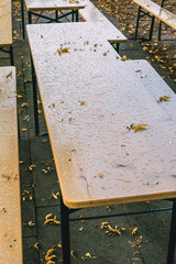 Empty beer garden in fall without guest due to rainy weather. Empty table and benches