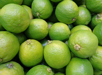 Closed up Pile of Vibrant Green Ripe Limes with Stem, for Background, Banner, Texture 