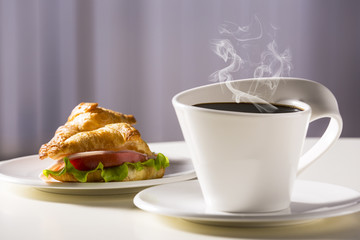 Coffee in a white cup with sandwiches. Breakfast is light.