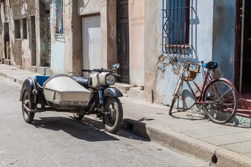 Motorcycle qith a side car and bicycle on the street in Camaguey, Cuba