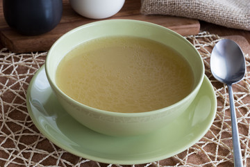 Chicken bone broth served in a green soup bowl
