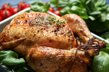 Baking dish with golden roasted turkey on table