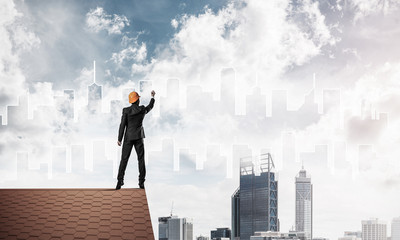 Man architect draw silhouette of modern city on blue sky. Mixed 