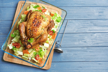 Baking dish with delicious turkey and vegetables on wooden background