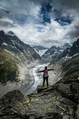 Naklejka premium Wanderin mit ausgestreckten Armen geniesst Aussicht auf den Mer de Glace Gletscher bei Montenvers, Chamonix