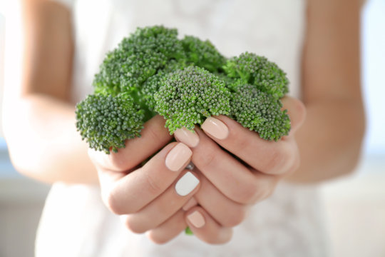 Fresh green broccoli in hands close-up