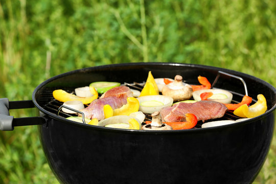 Barbecue grill with meat and vegetables outdoors, close up