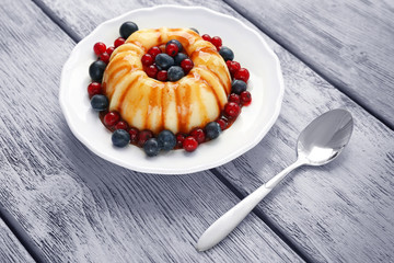 Tasty dessert with berries and spoon on table