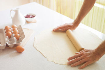 Man rolling dough, close-up photo