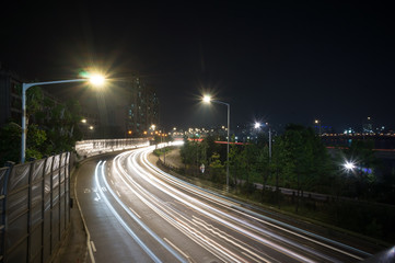 Fototapeta na wymiar Speed Traffic at Dramatic Sundown Time - light trails on motorway highway at night, long exposure. Seoul South Korea