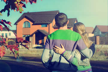 Rear view of young couple looking at their new house