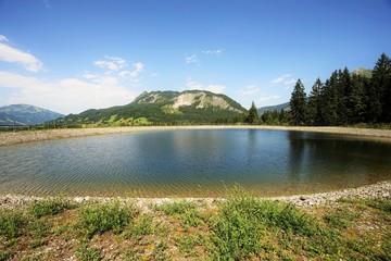 Fototapeta na wymiar The Einstein mountain in the Tyrolean Alps with storage pond in summer
