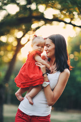 Obraz premium The baby plays with mother, warm summer days in the city park