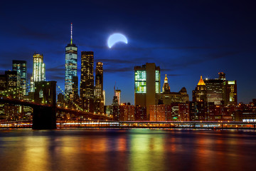 Fototapeta na wymiar Solar eclipse, New York NY august 21 2017New York City's Brooklyn Bridge and Manhattan skyline illuminated