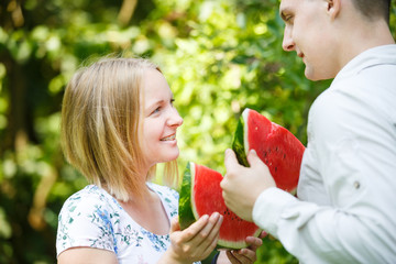 Fototapeta premium Couple is eating watermelon in a summer park